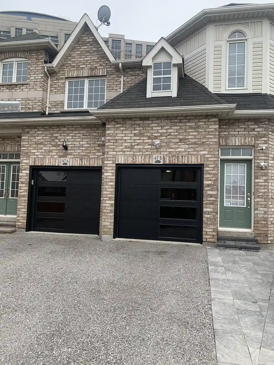 Contemporary black garage doors on a brick Toronto-area home