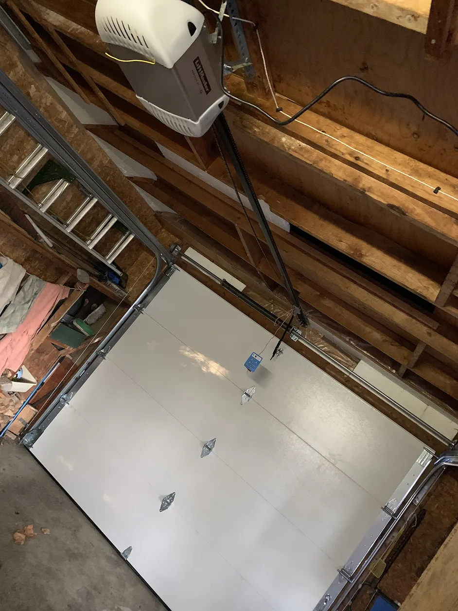 Garage door off track with visible cables and opener hardware in Toronto