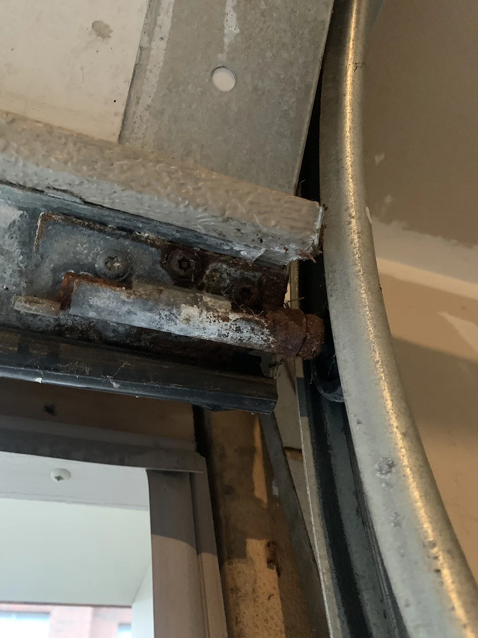 Corroded and damaged garage door track hardware in Toronto